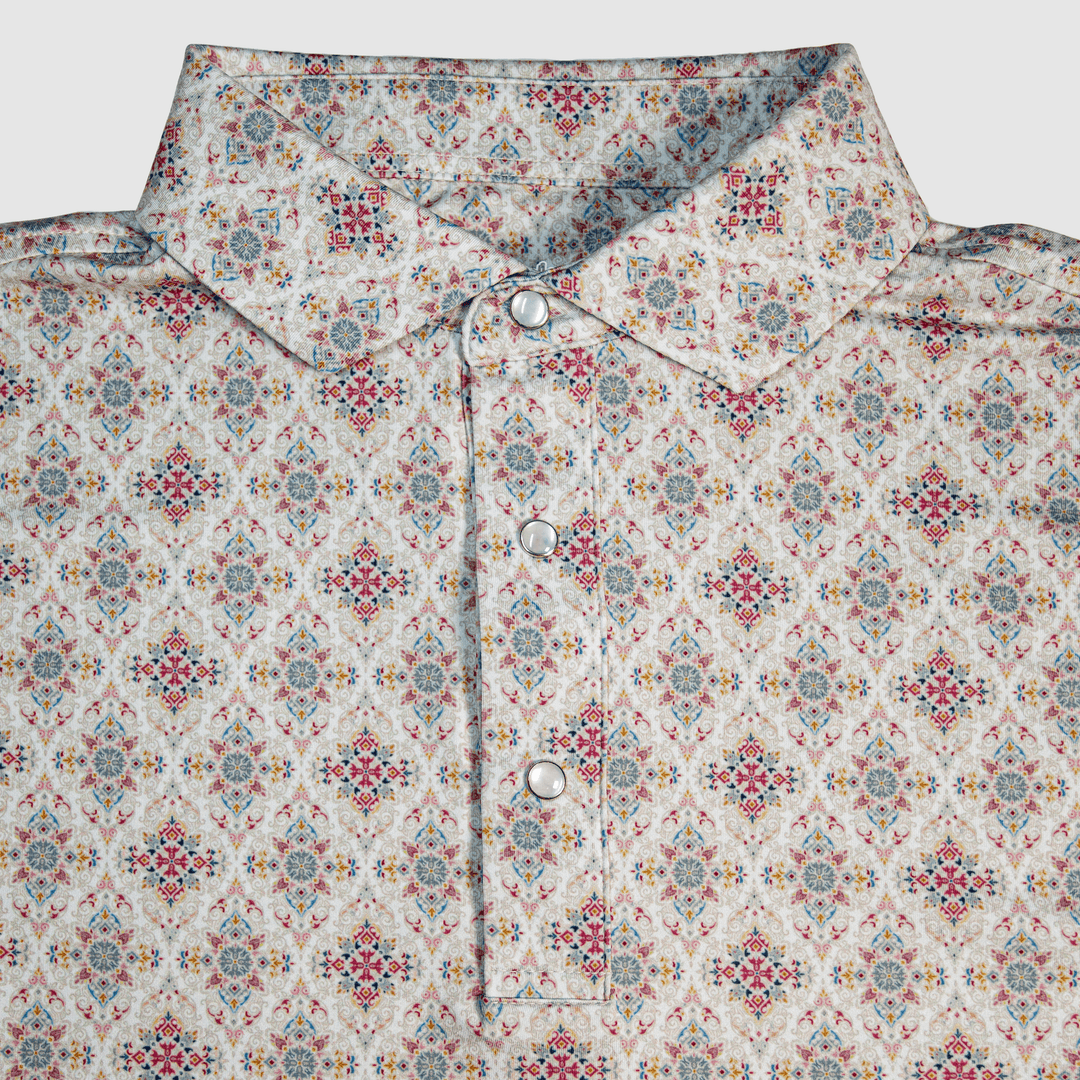 Flat lay of The Classic Pearl Snap Polo by Iron Oak Apparel, featuring an intricate floral western pattern with vibrant colors and signature pearl snap buttons. This stylish shirt blends modern design with Texan authenticity, perfect for any occasion.