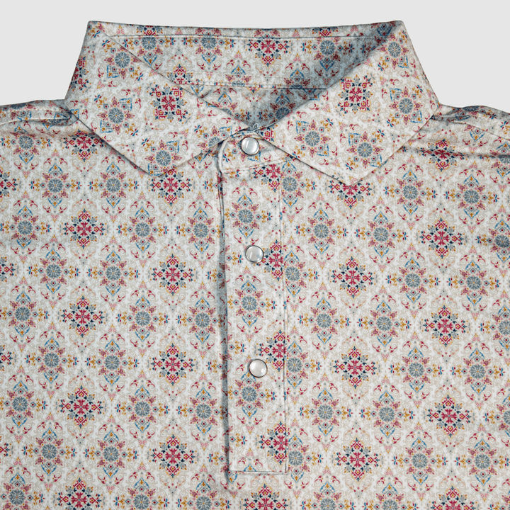 Flat lay of The Classic Pearl Snap Polo by Iron Oak Apparel, featuring an intricate floral western pattern with vibrant colors and signature pearl snap buttons. This stylish shirt blends modern design with Texan authenticity, perfect for any occasion.