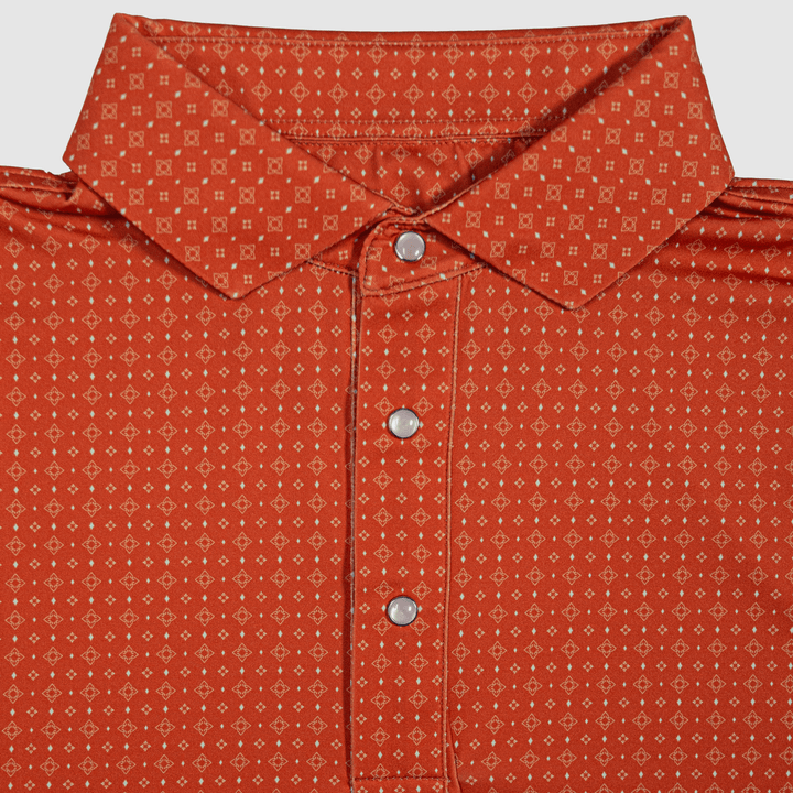 Flat lay of The Boone Pearl Snap Polo by Iron Oak Apparel, featuring a burnt orange western pattern and signature pearl snap buttons. This stylish shirt combines modern design with Texan authenticity, perfect for any casual or dressy occasion.