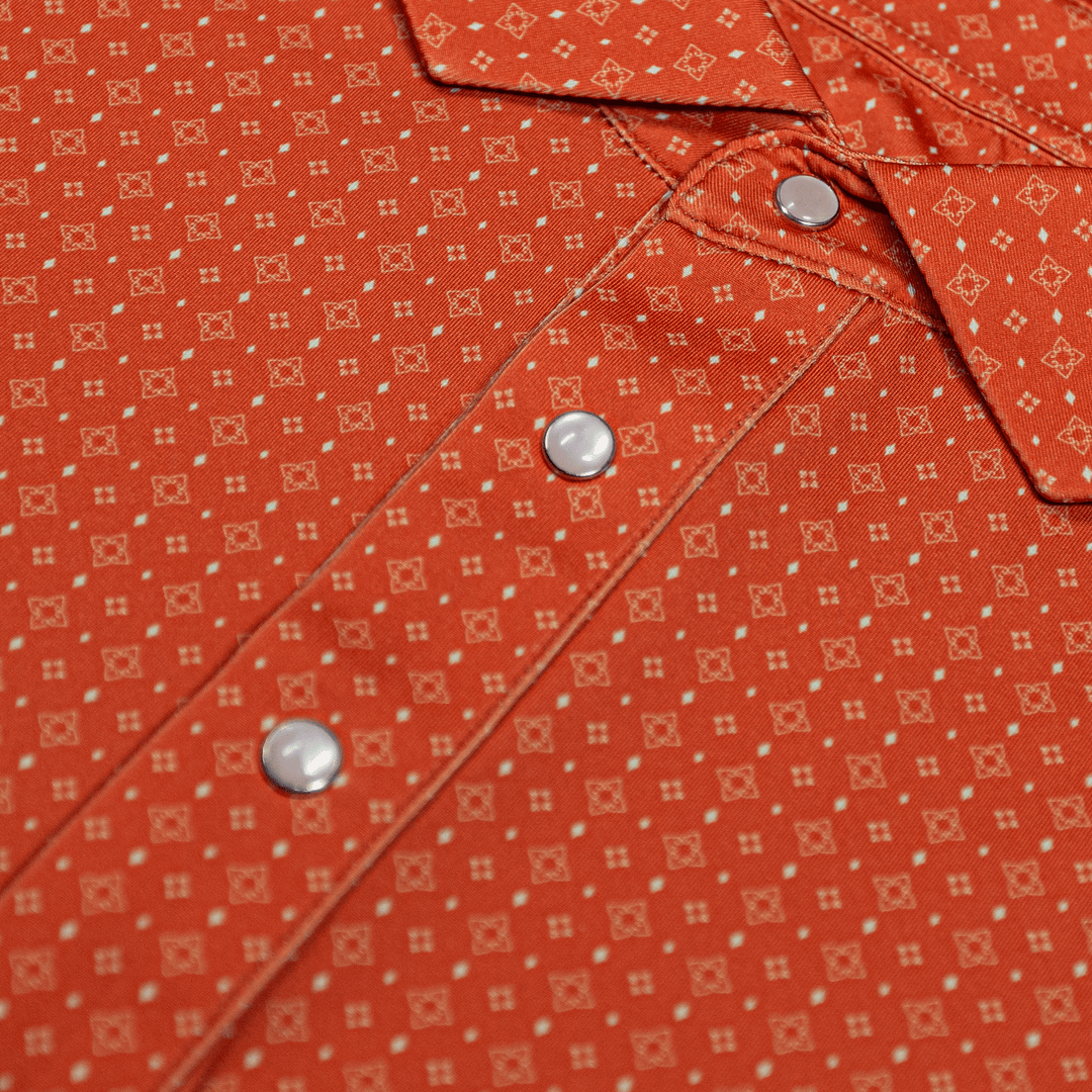 Close-up of The Boone Pearl Snap Polo by Iron Oak Apparel, showcasing a burnt orange western pattern and signature pearl snap buttons. This stylish shirt blends modern design with Texan authenticity, perfect for any casual or dressy occasion.