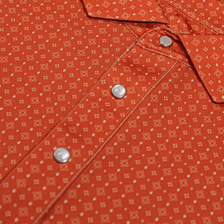 Close-up of The Boone Pearl Snap Polo by Iron Oak Apparel, showcasing a burnt orange western pattern and signature pearl snap buttons. This stylish shirt blends modern design with Texan authenticity, perfect for any casual or dressy occasion.