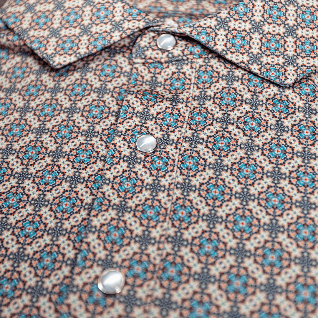 Detailed view of the pearl snap buttons and geometric western pattern on The Jaded Pearl Snap Polo by Iron Oak Apparel.