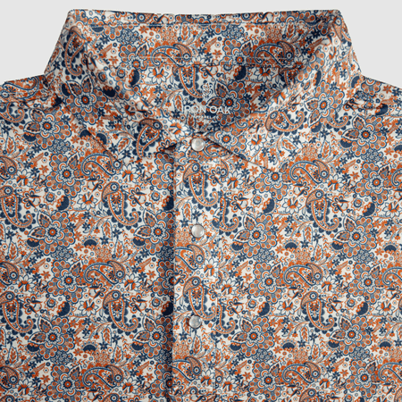 Flat lay of The Dosey Doe Pearl Snap Polo by Iron Oak Apparel, featuring a vibrant paisley Western pattern in shades of orange, blue, and white. The shirt displays signature pearl snap buttons and a stylish collar, perfect for a bold statement.