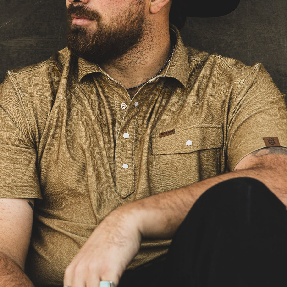 Model wearing the Dusty golden brown polo, showing its collar, pocket and western styling