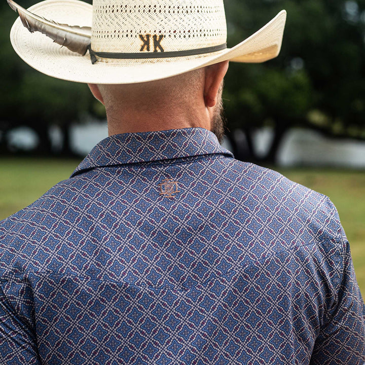 Back view of The Granger Western Yoke Pearl Snap Polo by Iron Oak Apparel, featuring the classic blue Western pattern with the embroidered Iron Oak logo.