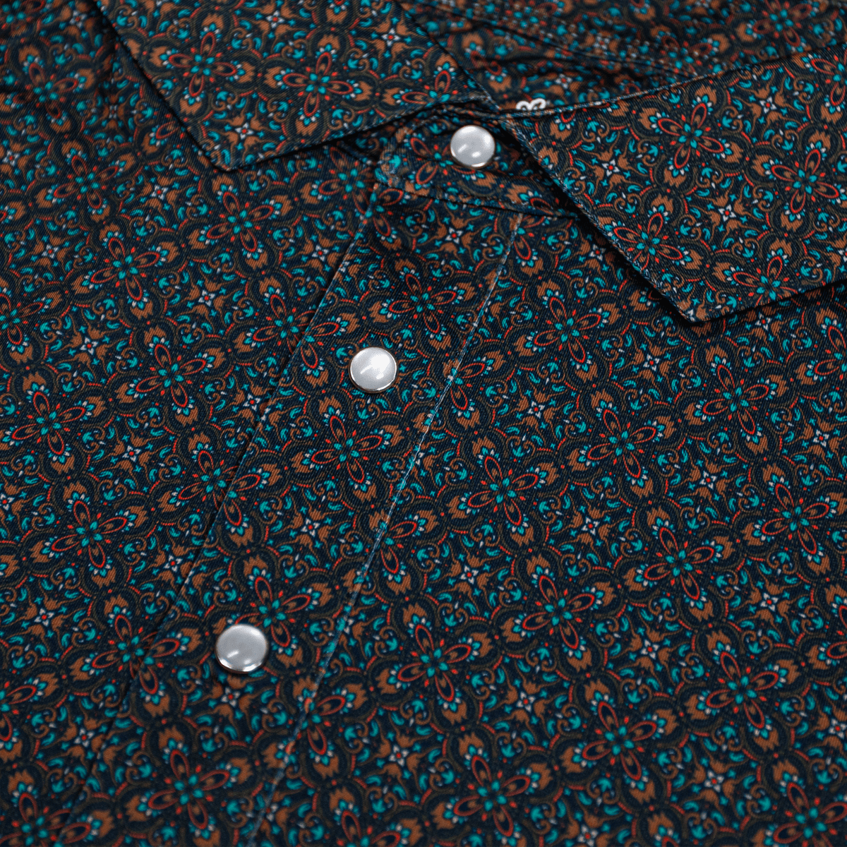 Close-up of the Pearl Snap Polo by Iron Oak Apparel, showcasing its intricate geometric pattern and signature pearl snap buttons. This stylish shirt combines modern design with Texan authenticity, perfect for elevating casual outfits.