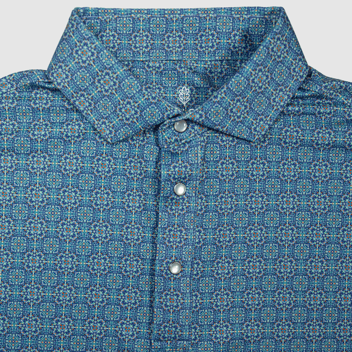 Flat lay of The Boot Scoot Pearl Snap Polo by Iron Oak Apparel, featuring a vibrant blue western pattern and signature pearl snap buttons. This stylish shirt blends modern design with Texan authenticity, perfect for any casual or dressy occasion.