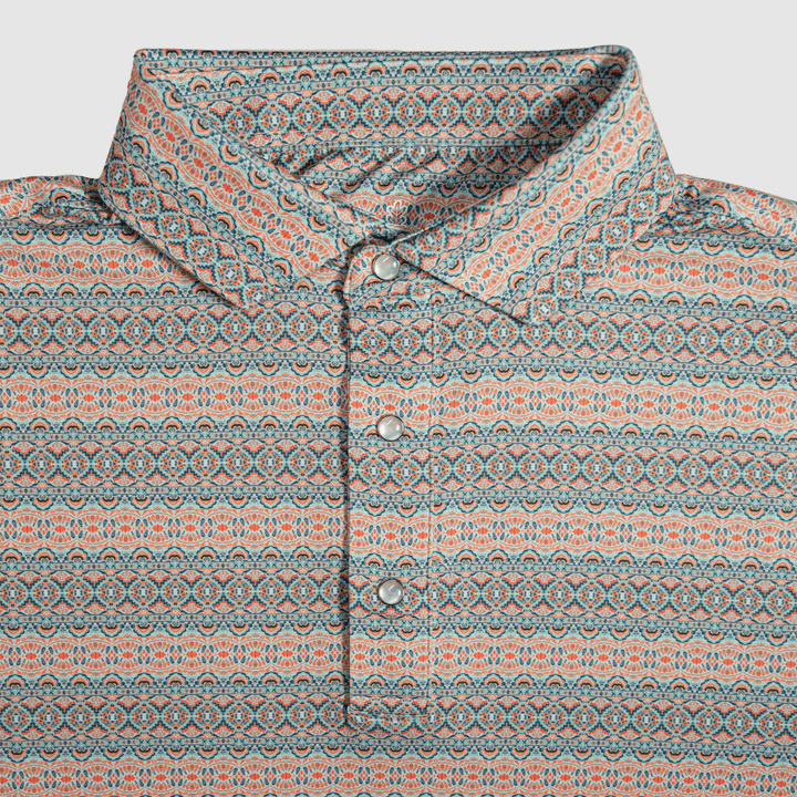 Flat lay of The Desperado Pearl Snap Polo by Iron Oak Apparel, featuring a colorful horizontal Western pattern with shades of blue, orange, and white. The shirt showcases signature pearl snap buttons and a stylish collar, perfect for adding a bold statement to your wardrobe.